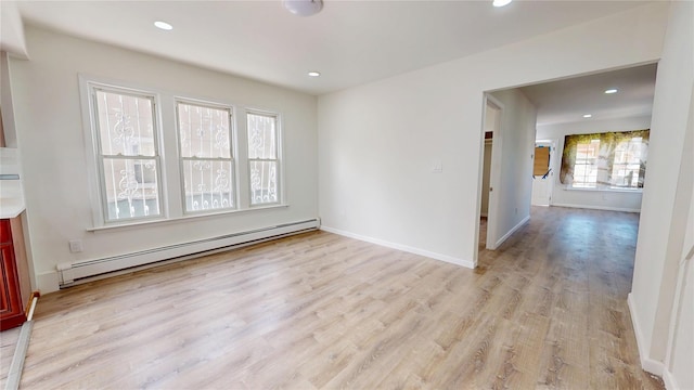 empty room with baseboards, baseboard heating, light wood-style flooring, and recessed lighting