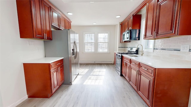 kitchen with appliances with stainless steel finishes, light countertops, and backsplash