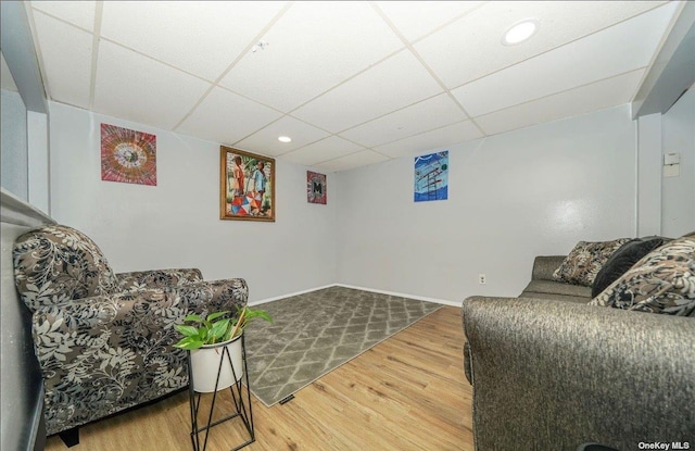 living room with a paneled ceiling, recessed lighting, baseboards, and wood finished floors