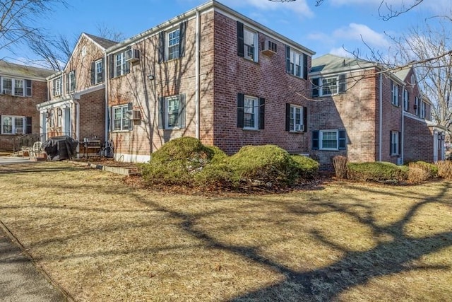 view of property exterior with brick siding and a lawn