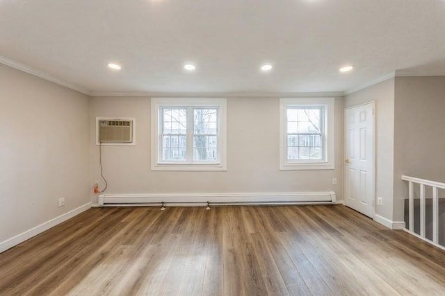 empty room with baseboards, wood finished floors, crown molding, a baseboard heating unit, and a wall mounted AC