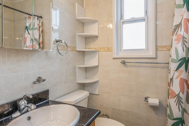 full bathroom with toilet, curtained shower, tile walls, and vanity