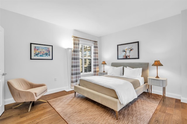 bedroom featuring wood finished floors and baseboards