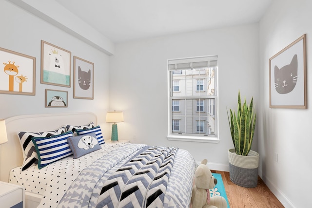 bedroom featuring baseboards and wood finished floors