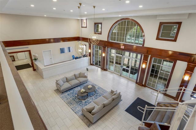 sunken living room with a towering ceiling, an inviting chandelier, and recessed lighting