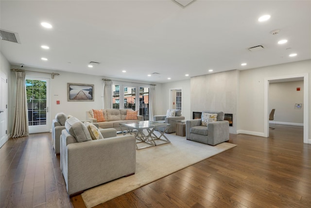 living area with baseboards, visible vents, hardwood / wood-style floors, and recessed lighting