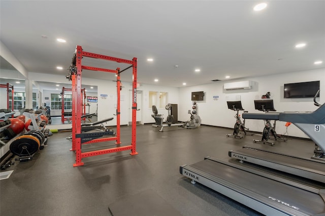 exercise room with baseboards, a wall mounted air conditioner, and recessed lighting