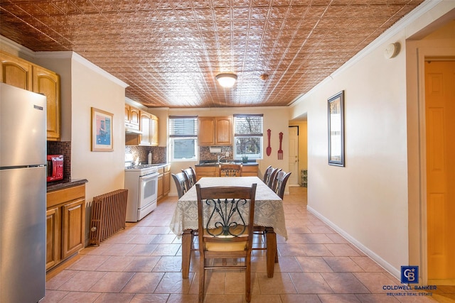 dining room featuring an ornate ceiling, crown molding, and baseboards