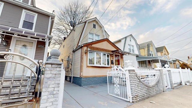 view of front facade featuring a fenced front yard, a gate, and a gambrel roof