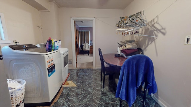 laundry room featuring washer and dryer, laundry area, marble finish floor, and baseboards