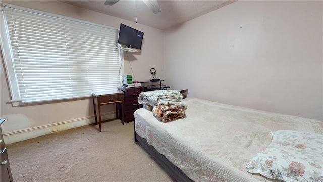 bedroom with a ceiling fan and light colored carpet