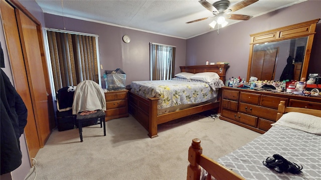 bedroom with ceiling fan, ornamental molding, a textured ceiling, and light colored carpet