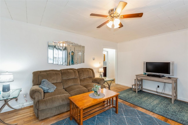 living room featuring ceiling fan, wood finished floors, and baseboards