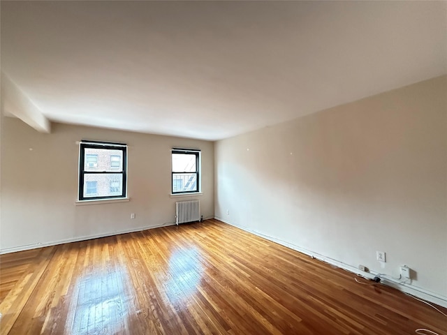 spare room with light wood-type flooring and radiator heating unit