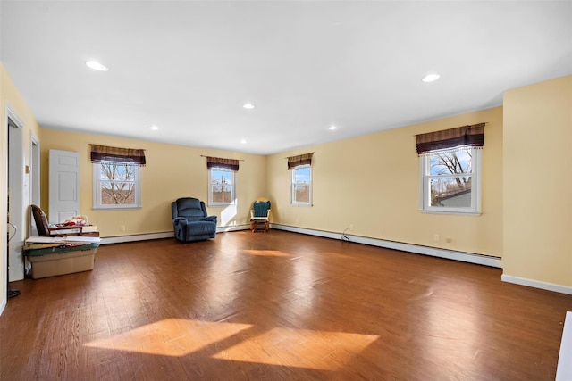 unfurnished room with a wealth of natural light, baseboard heating, wood finished floors, and recessed lighting