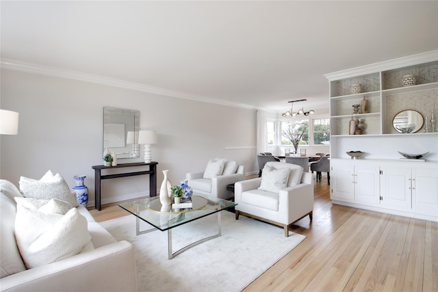 living room featuring light wood finished floors, ornamental molding, and a notable chandelier