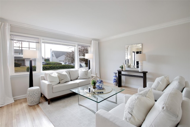 living room featuring baseboards, ornamental molding, and wood finished floors