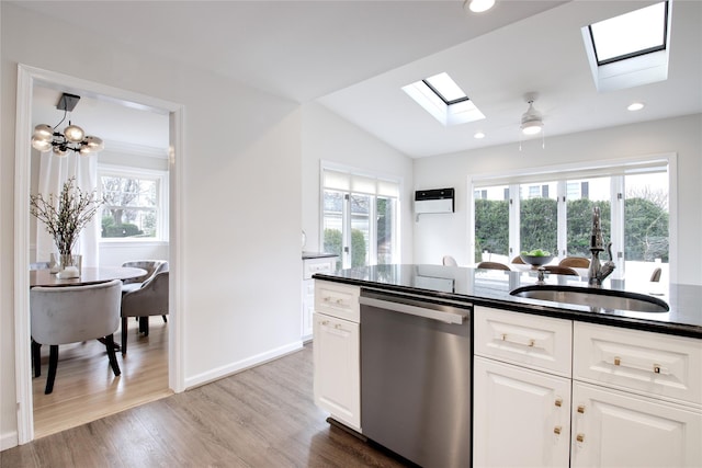 kitchen with stainless steel dishwasher, plenty of natural light, light wood-style flooring, and white cabinets