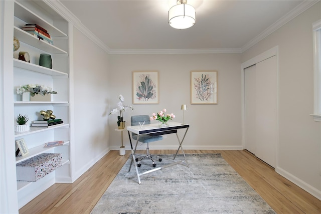 office area with built in shelves, crown molding, baseboards, and wood finished floors