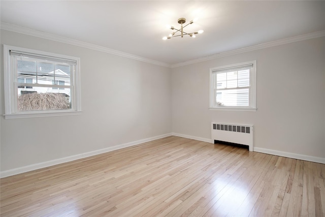 empty room featuring radiator, a notable chandelier, crown molding, and hardwood / wood-style floors