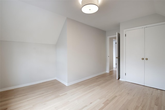 bonus room featuring lofted ceiling, light wood-style flooring, and baseboards