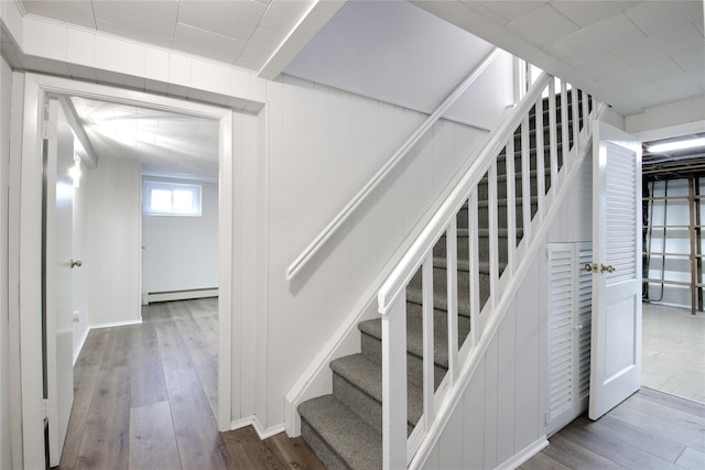 stairway featuring hardwood / wood-style flooring and a baseboard radiator