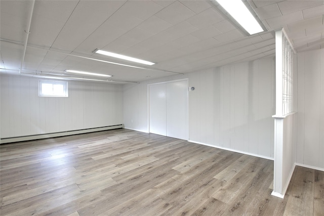 basement with a baseboard radiator and wood finished floors