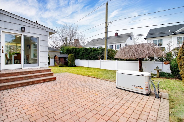 view of patio featuring an outbuilding, fence, and a shed