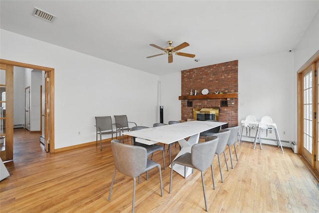 97 Ludlam Rd, Monroe, NY 10950 - dining space with light wood-type flooring, a fireplace, a ceiling fan, baseboard heating, and baseboards