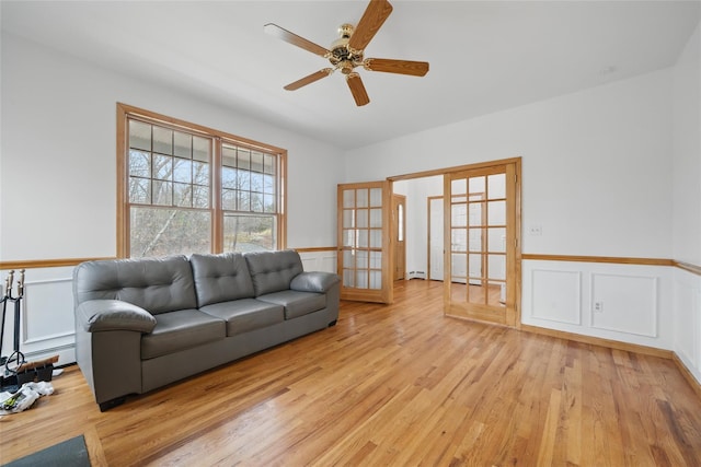 97 Ludlam Rd, Monroe, NY 10950 - living room featuring light wood-style flooring, french doors, ceiling fan, a wainscoted wall, and a decorative wall