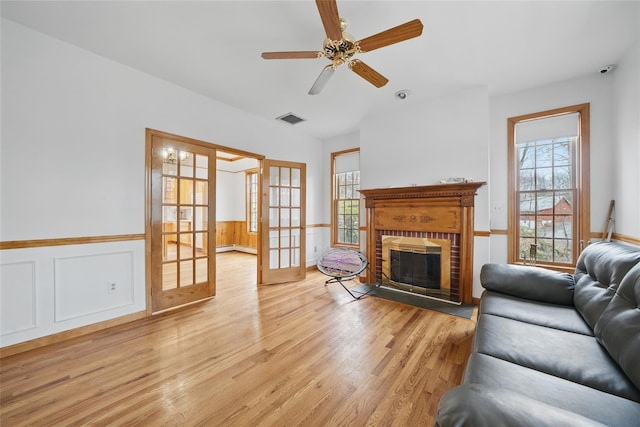 97 Ludlam Rd, Monroe, NY 10950 - living room with plenty of natural light, light wood finished floors, a wainscoted wall, a ceiling fan, and a fireplace