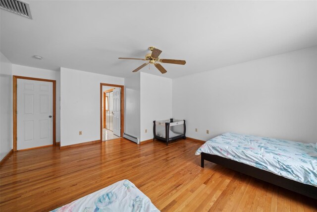 97 Ludlam Rd, Monroe, NY 10950 - bedroom featuring a baseboard radiator, light wood-type flooring, baseboards, and a ceiling fan