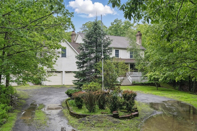 97 Ludlam Rd, Monroe, NY 10950 - view of property hidden behind natural elements with driveway, a chimney, and a garage