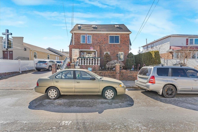 view of front of house with brick siding and fence