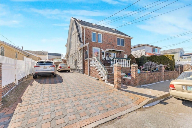 view of front of home with a fenced front yard and brick siding