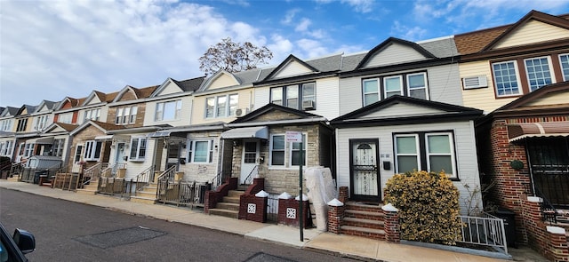 townhome / multi-family property with stone siding and a residential view