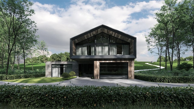 modern home featuring a garage, a balcony, a front lawn, and concrete driveway