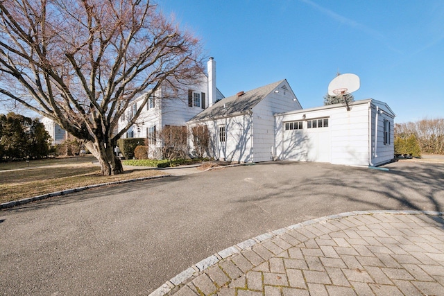 view of side of property featuring an attached garage and driveway