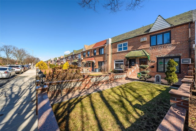 view of front of house with a residential view, brick siding, and a front yard