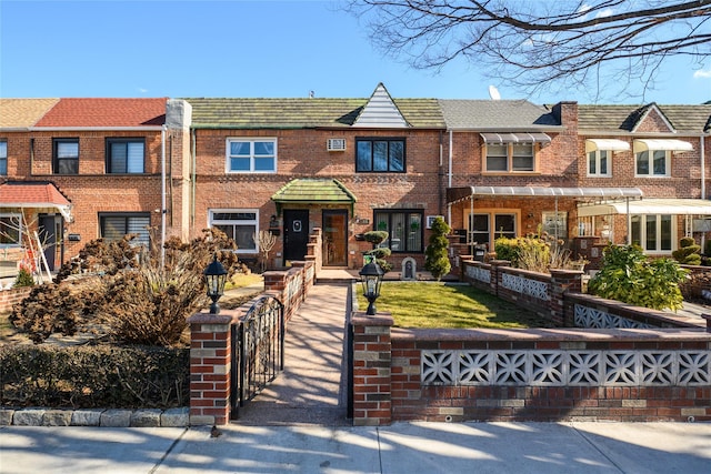 multi unit property featuring a fenced front yard and brick siding