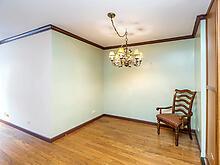 living area featuring baseboards, a chandelier, wood finished floors, and crown molding