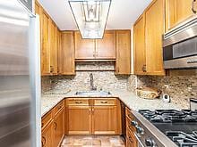 kitchen with appliances with stainless steel finishes, brown cabinetry, light countertops, and decorative backsplash