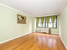 spare room featuring ornamental molding, radiator heating unit, wood finished floors, and baseboards