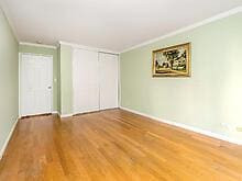 unfurnished bedroom featuring a closet, crown molding, baseboards, and wood finished floors