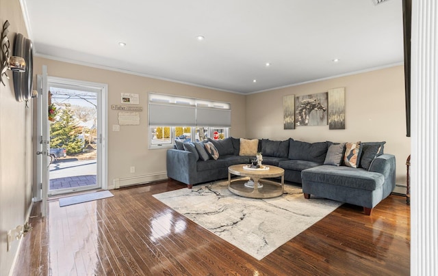 living area featuring a baseboard heating unit, crown molding, baseboards, and hardwood / wood-style flooring