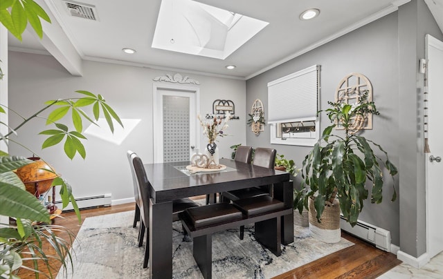 dining area with a baseboard heating unit, ornamental molding, a skylight, and visible vents