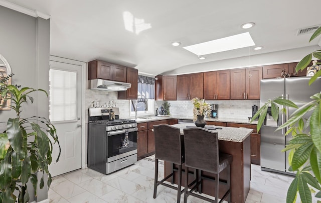 kitchen featuring visible vents, appliances with stainless steel finishes, light stone counters, marble finish floor, and under cabinet range hood