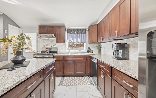 kitchen featuring appliances with stainless steel finishes, marble finish floor, under cabinet range hood, and light stone countertops