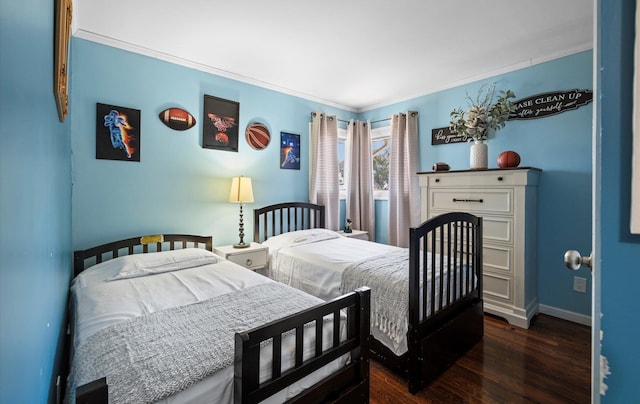 bedroom featuring baseboards, dark wood-style flooring, and crown molding