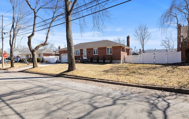 ranch-style house with a garage, a chimney, a gate, fence, and brick siding